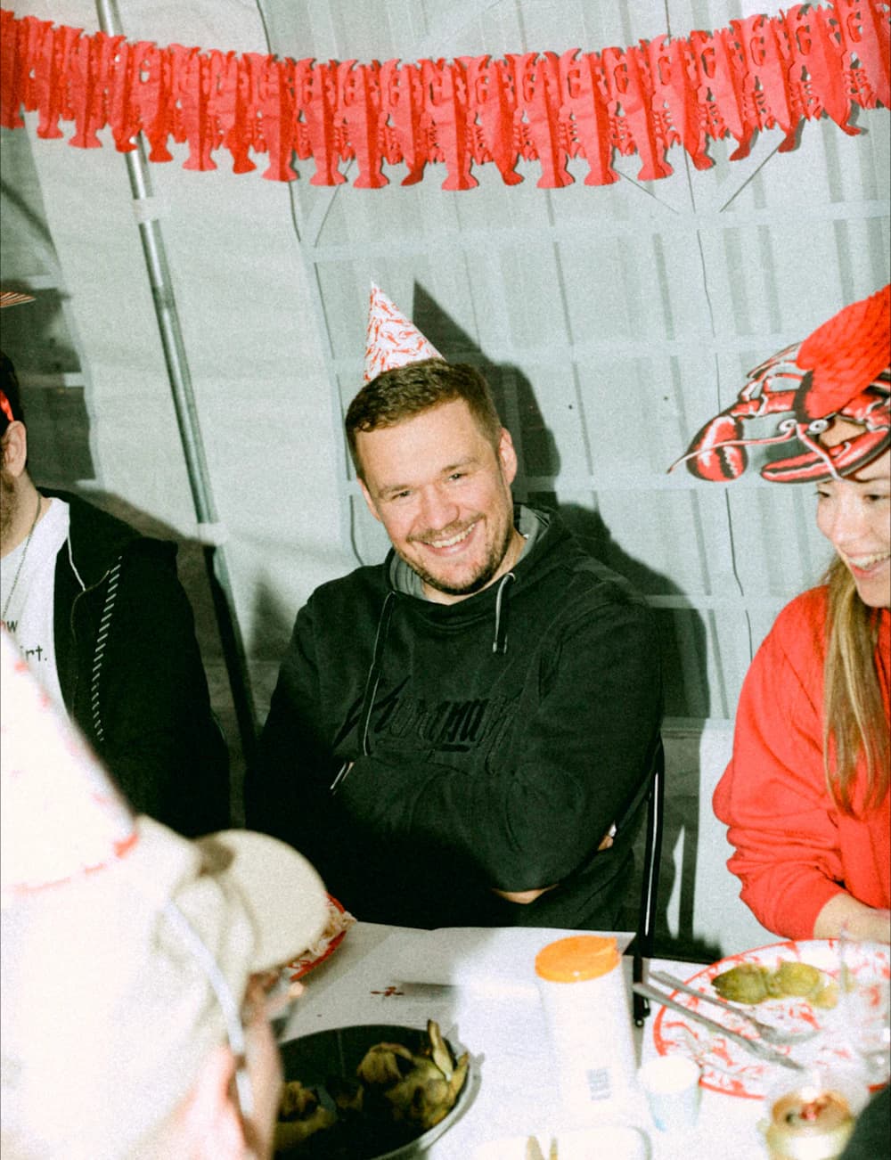 En kumpan med partyhatt på kräftskivan
